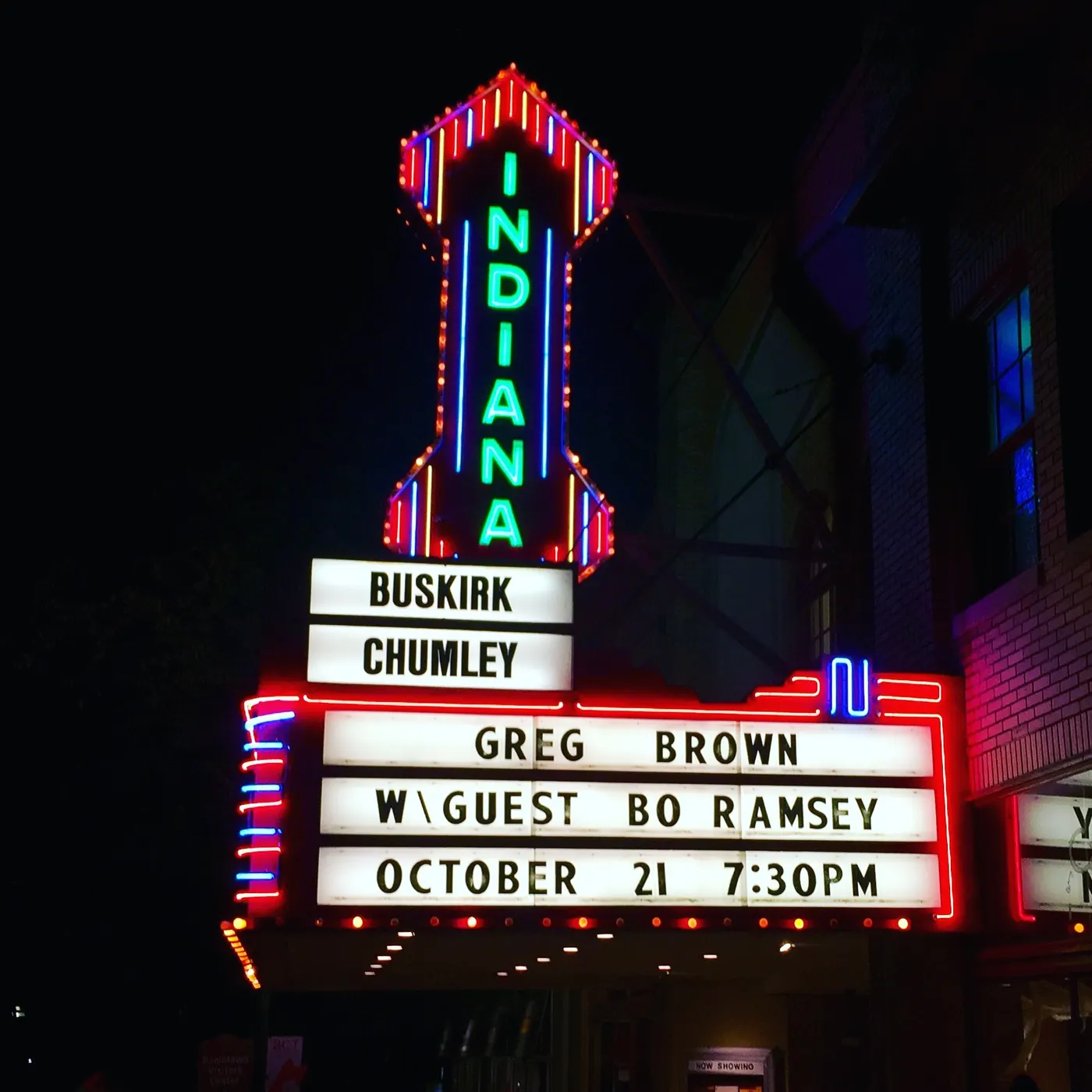 The lit Indiana Theater sign and marquee at night, its letter boards announcing an upcoming show